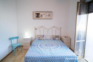维拉诺瓦Monolocale ilporticciolovacanze的一间卧室配有蓝色的床和蓝色椅子
