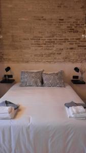 塞维利亚Carmona&House的一张带两个枕头的大白色床