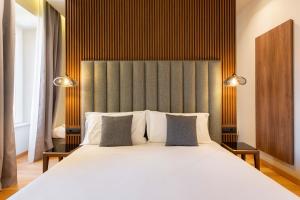 罗马ELICAL Exclusive Private Suites的卧室配有一张带两个枕头的大白色床