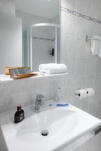 博讷Sure Hotel by Best Western Centre Beaune的白色的浴室设有水槽和镜子