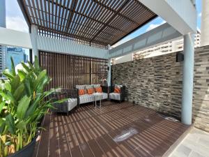 曼谷Citrus Suites Sukhumvit 6 by Compass Hospitality的庭院设有木甲板、椅子和砖墙