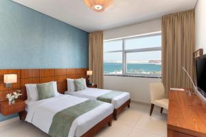 多哈多哈辉盛阁国际公寓的酒店客房设有两张床和窗户。