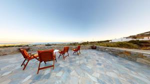 克里希阿克提ONAR RESIDENCE PAROS的俯瞰大海的庭院设有三把椅子和一张桌子