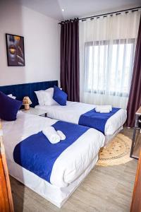 安齐拉贝Yvanka Appart'City Antsirabe的两张带蓝色和白色床单的床