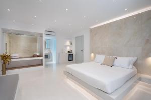 费拉Cycladic Suites的白色卧室配有一张白色的大床