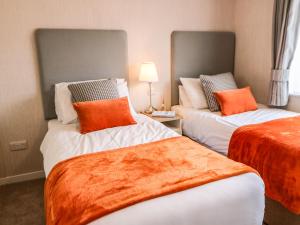 里士满Rashierigg的两张带橙色枕头的床