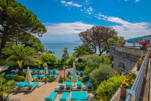 奥帕提亚阿玛迪利亚公园米勒尼酒店的享有带椅子和遮阳伞的度假村的游泳池景致