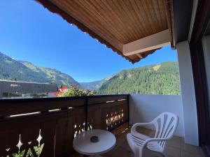 沙泰勒Hôtel Macchi Restaurant & Spa的阳台配有桌椅,享有山景。