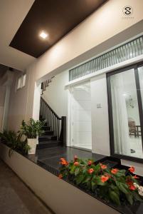 芽庄Moonlight House & Apartment Nha Trang的一座房子,在地板上设有一个种有鲜花的阳台