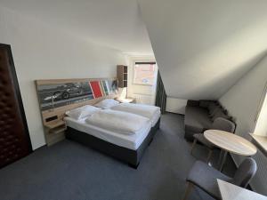 尼尔堡特尔伽藤酒店的卧室配有1张床、1张桌子和1把椅子