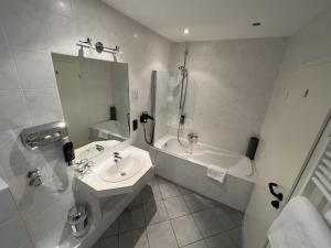 尼尔堡特尔伽藤酒店的白色的浴室设有水槽和浴缸。