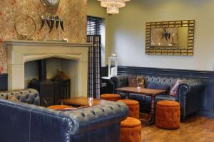圣海伦斯The Eccleston Hotel; BW Signature Collection的餐厅设有蓝色皮革家具和壁炉