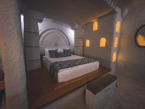格雷梅本地岩洞酒店的石头建筑中一间带床的卧室