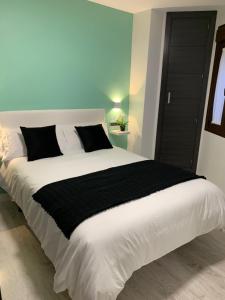 隆达APARTAMENTO LAS NIÑAS的卧室配有一张带黑色毯子的大型白色床。