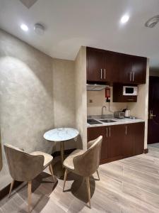 迪拜City Seasons Suites的厨房配有桌椅和柜台。