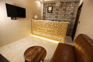 法里达巴德Hotel Lavit Couple Friendly near Faridabad Metro station的酒店等候室设有桌子和电视