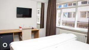 雷克雅未克Center Hotels Klopp的酒店客房设有一张床、一张书桌和窗户。
