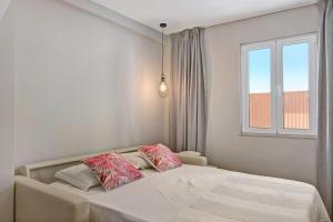 法鲁Casa Rebelo da Silva的一间卧室配有带粉色和白色枕头的床