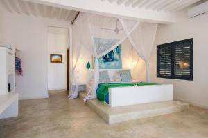 米查维Upendo Beach Boutique Hotel Zanzibar的一间卧室配有一张带天蓬的床