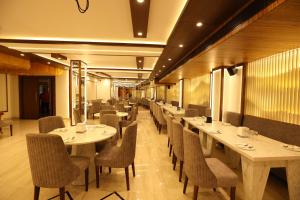 法里达巴德Hotel Lavit Couple Friendly near Faridabad Metro station的餐厅里一排桌椅