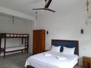 阿鲁甘湾Surf Gangs Arugambay的一间卧室配有一张床,上面有两条毛巾