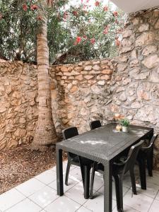 威廉斯塔德Casa di Caribe - palmtree的一张黑色桌子和椅子,在石墙前