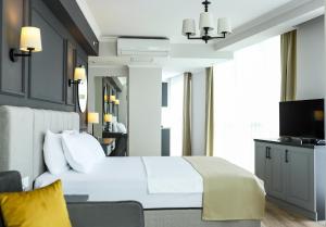 伊斯坦布尔FONTANA VERDE的卧室配有白色的床和电视。