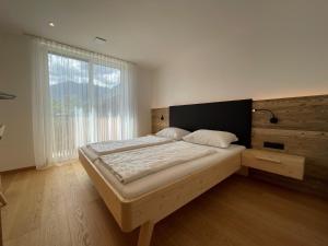 布列瑟农Mesnerhof Chalet的一间卧室设有一张大床和一个大窗户