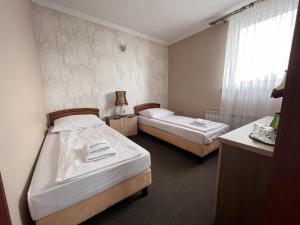 MogilnoNoclegi-Restauracja Boss的小型客房 - 带2张床和窗户