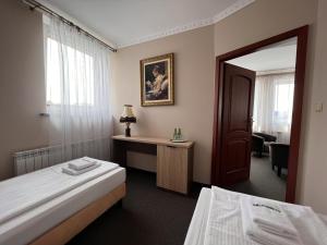 MogilnoNoclegi-Restauracja Boss的酒店客房,设有两张床和镜子