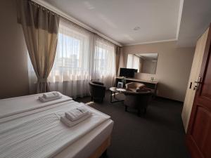 MogilnoNoclegi-Restauracja Boss的酒店客房配有两张床和一张书桌