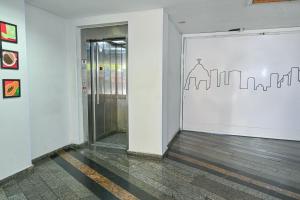 里约热内卢Hotel Vital, Rio de Janeiro的走廊上设有一扇门,墙上挂着画图