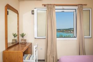 查加基恩Bella Vista Sea View Apartments的一间卧室配有镜子、梳妆台和窗户