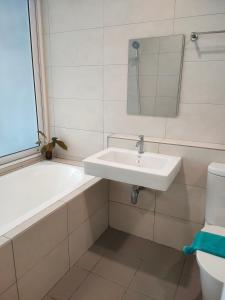 怡保八角形怡保公寓的一间带水槽、浴缸和卫生间的浴室