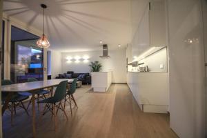 卢森堡Kirchberg Apartment - High End 2 Bedrooms in Luxembourg City的厨房以及带桌椅的起居室。