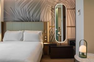 米兰Boutique Hotel Martini 17的酒店客房,配有床和镜子