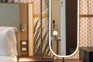 米兰Boutique Hotel Martini 17的卧室配有镜子,位于床边