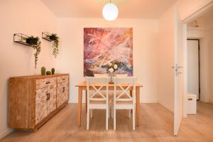 沃伦塔里Urban Bliss - Contemporary Elegance in Modern Living Spaces的一间带桌子和绘画的用餐室
