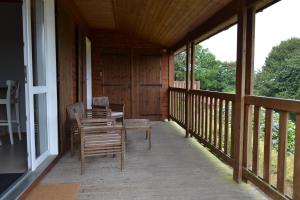 Saint-Manvieu-BocageBeautiful lake view 3 bedroom chalet.的小屋的门廊配有椅子和桌子