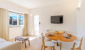 阿尔沃尔Pestana Alvor Beach Villas Seaside Resort的客厅设有餐桌和沙发