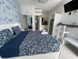 蓬塔卡纳Costa Love Aparta Hotel的一间带蓝色和白色床的卧室和一间厨房