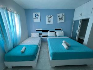 蓬塔卡纳Costa Love Aparta Hotel的蓝色墙壁客房的两张床