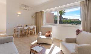 阿尔沃尔Pestana Alvor Beach Villas Seaside Resort的客厅配有椅子、桌子和窗户