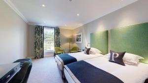 哈罗盖特罗丁公园酒店的酒店客房配有两张床和一张书桌