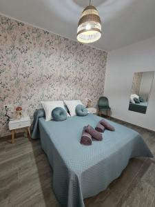 内尔哈COLON Nerja的一间卧室配有一张带蓝色毯子和鲜花的床。