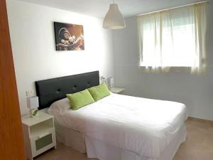 塞埃APARTAMENTO PLAYA DE ESTORDE的一间卧室配有带白色床单和绿色枕头的床。