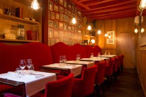 博讷Les Chambres de L'Ecrit'Vin - En plein coeur du centre-ville的餐厅的一排桌子和红色椅子
