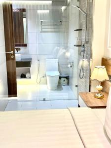 绥和市White House Condotel Phú Yên的一间带卫生间和玻璃淋浴间的浴室