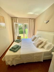 卡兰博希Bonito apartamento con terraza, jardín y piscina的卧室配有一张大白色床和窗户