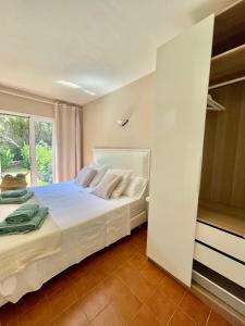 卡兰博希Bonito apartamento con terraza, jardín y piscina的卧室配有白色的床和窗户。